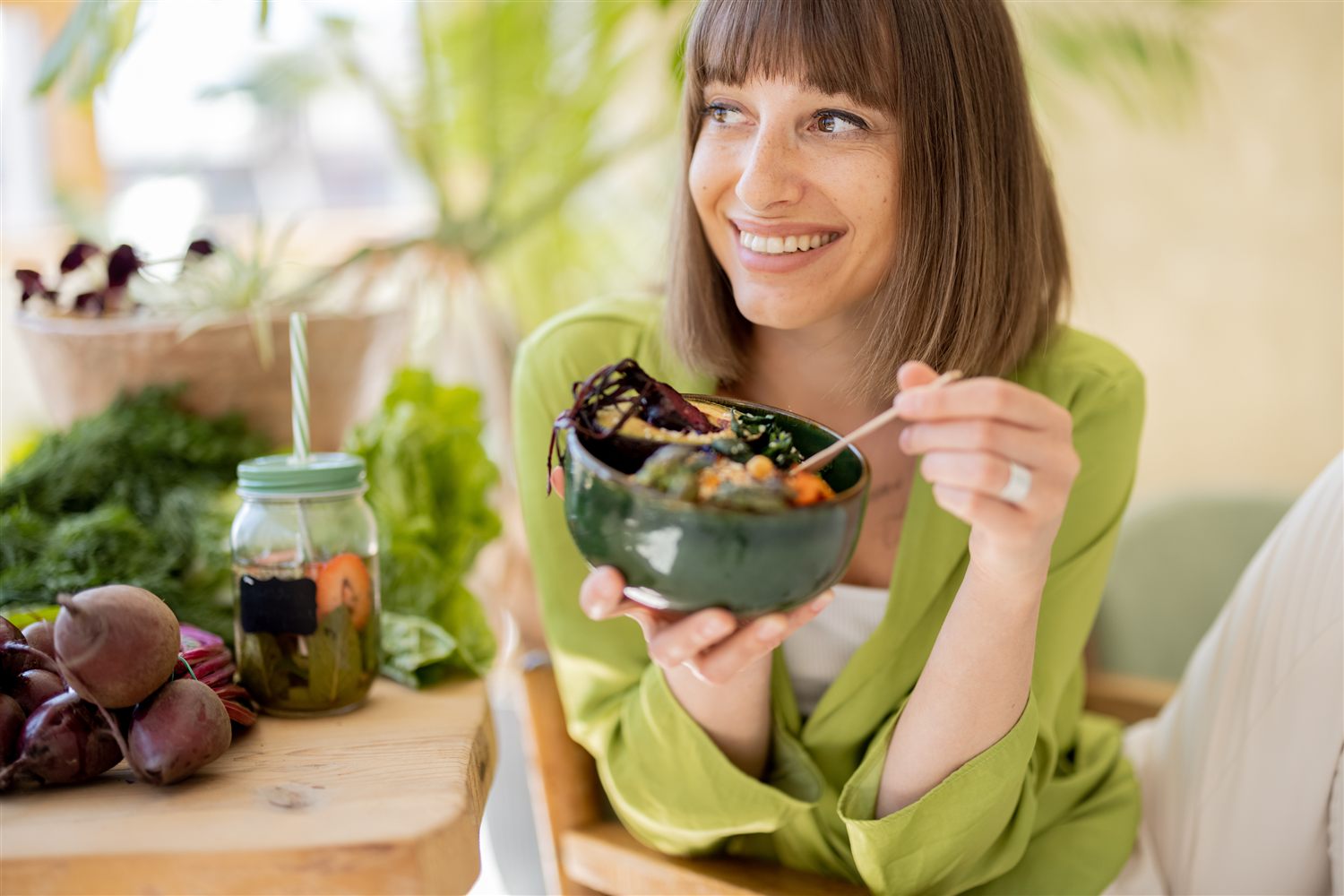 A woman enjoying a fresh vegetarian salad bowl